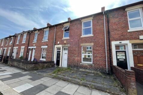 A charming row of traditional terraced brick ho...