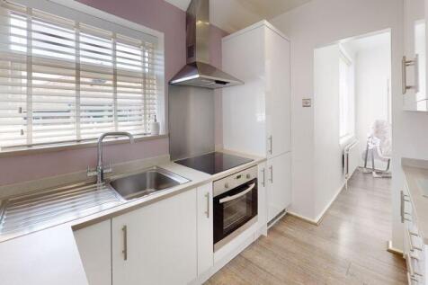 Bright modern kitchen featuring white cabinetry...