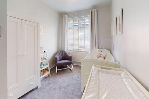 A bright and clean single bedroom featuring a c...