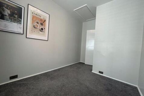 A small, clean single bedroom featuring neutral...