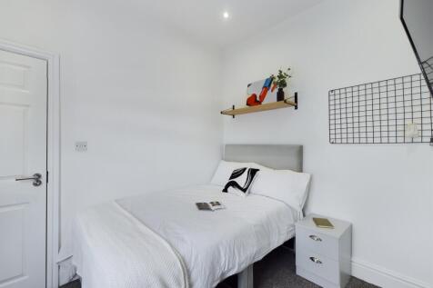 A bright and tidy double bedroom featuring mode...