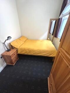 A cozy double bedroom featuring a bright yellow...