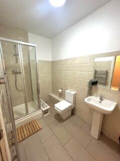 A clean and modern bathroom featuring a glass-e...