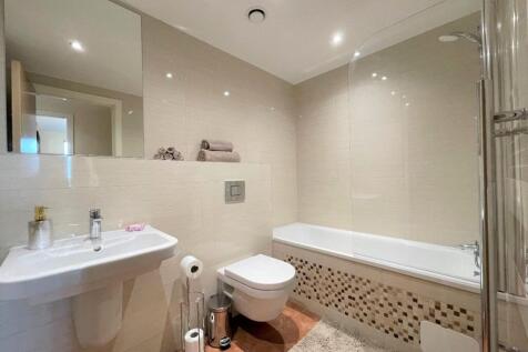 Bright and modern bathroom suite featuring a cl...
