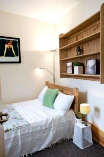 Cozy single bedroom featuring a neatly made bed...