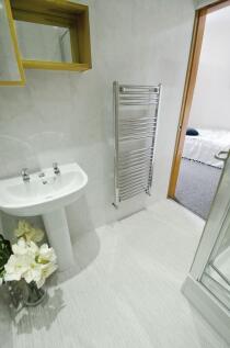 Bright and clean bathroom featuring a white ped...