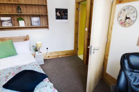 A cozy single bedroom featuring a comfortable b...