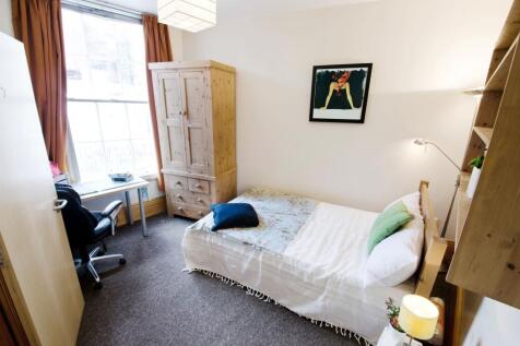 Cozy single bedroom featuring a comfortable bed...