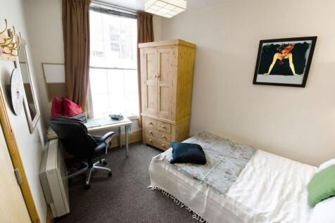 Cozy single bedroom featuring a comfortable bed...