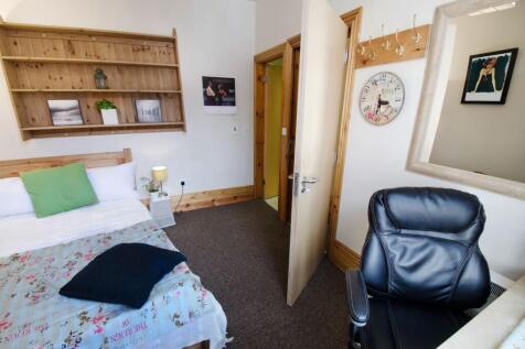 A cozy room featuring a comfortable bed with de...