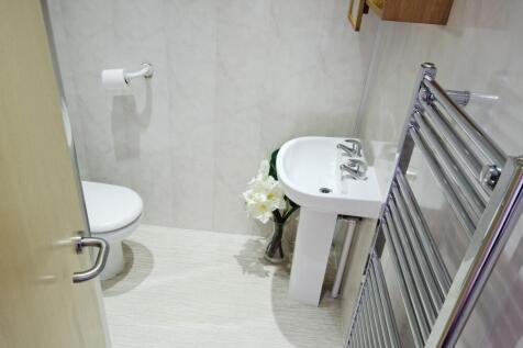 A clean, modern single toilet room featuring a ...