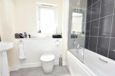 Bright and modern bathroom suite featuring a cl...