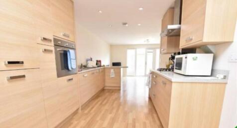 A modern kitchen featuring light wood cabinetry...