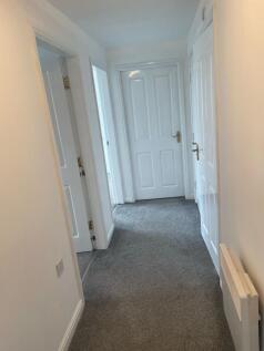 A clean and well-maintained hallway with light-...