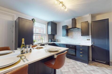 This modern kitchen boasts sleek cabinetry and ...