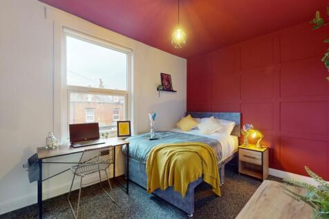 This cozy double bedroom features a comfortable...