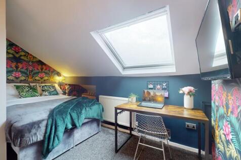 This inviting double bedroom features a cozy be...