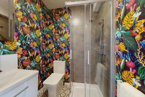 This vibrant and modern bathroom features a sty...
