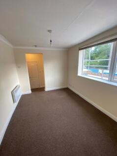A clean and simple single bedroom featuring a l...