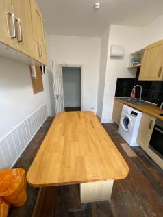 A compact kitchen featuring wooden cabinetry an...