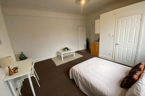 A spacious master bedroom featuring a comfortab...