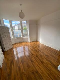 Bright and spacious bedroom with warm wooden fl...