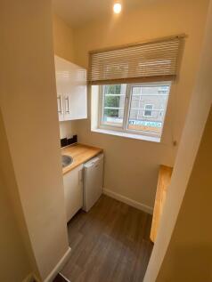 Compact and tidy kitchenette featuring light wo...