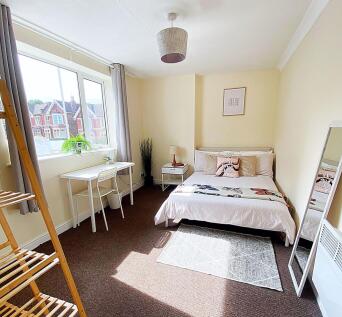 Bright and welcoming double bedroom featuring a...