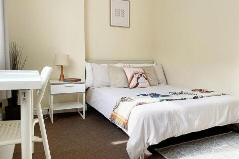 A bright and cozy double bedroom featuring a co...
