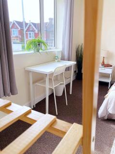 Bright and cozy single bedroom featuring a neat...