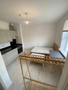 Compact and clean room featuring a small kitche...