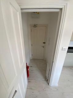 A clean and bright hallway featuring white wall...