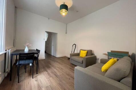 A bright and tidy living room featuring two com...