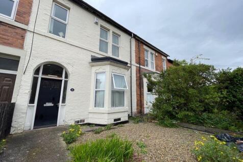 Charming terraced house exterior with a neat gr...
