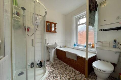 Bright and clean bathroom suite featuring a cor...