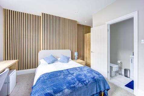 A modern and stylish master bedroom featuring a...