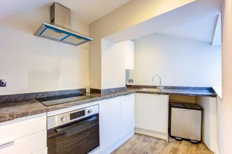 Bright and modern kitchen featuring sleek white...