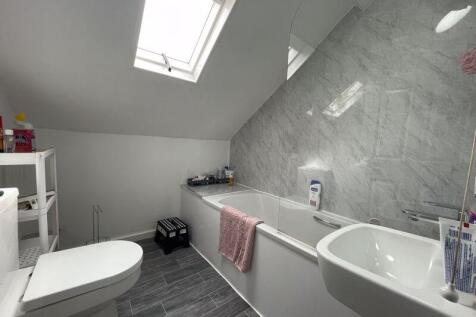 A bright and modern bathroom suite featuring a ...