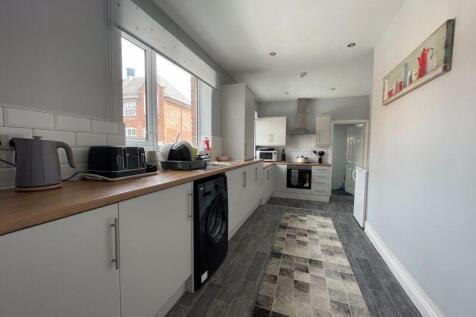 A bright and modern kitchen featuring white cab...