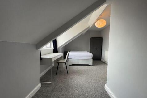 A bright, tidy single bedroom featuring a minim...