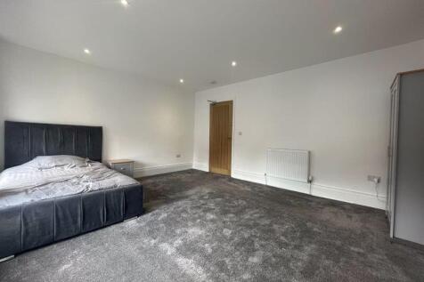 A spacious and modern master bedroom featuring ...