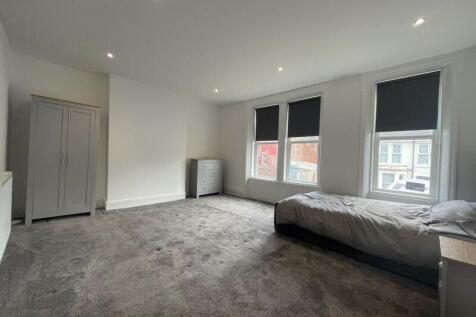 A spacious and bright master bedroom featuring ...