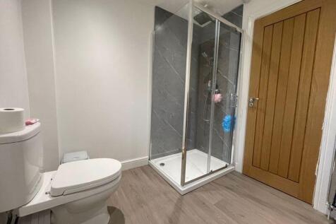 A modern bathroom featuring a spacious walk-in ...