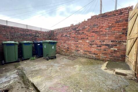 A small, private outdoor space enclosed by bric...