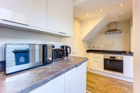 Bright and modern kitchen featuring sleek white...