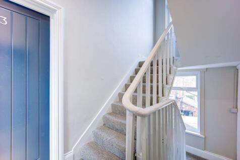Bright and clean staircase area with white rail...