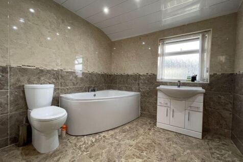 A spacious and modern bathroom suite featuring ...