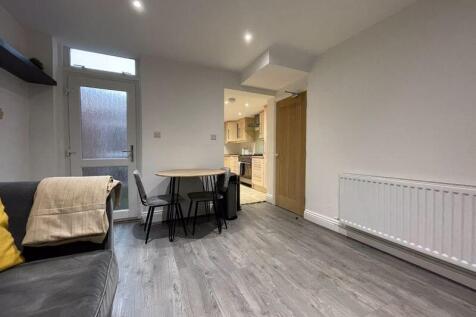 A modern living room with grey flooring and whi...