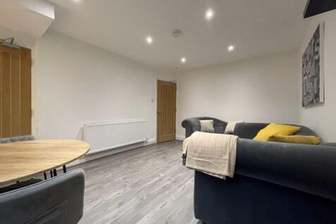 A modern and tidy living room featuring a comfo...