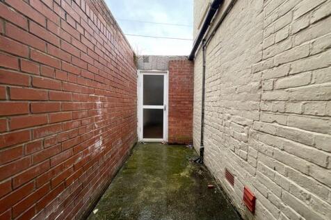 A narrow outdoor storage alleyway between two b...